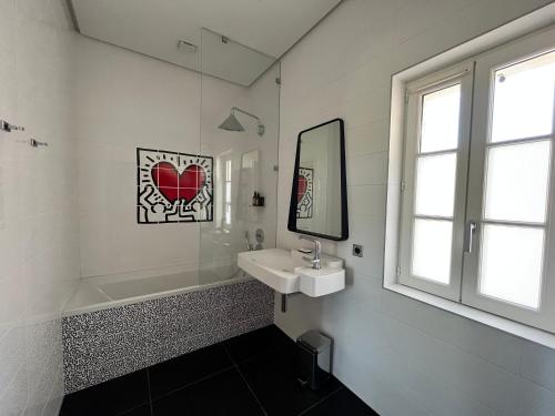 uma casa de banho branca com um lavatório e um espelho em Oasis Fontmarie - appartement en pleine nature em Castries