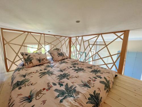um quarto com uma cama grande e uma colcha floral em Oasis Fontmarie - appartement en pleine nature em Castries