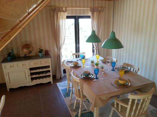 a dining room with a table with chairs and a window at Villa Ana in Nazaré