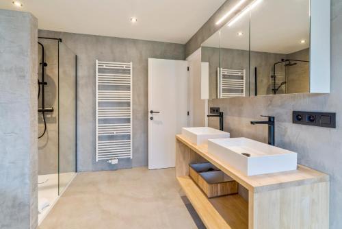 a bathroom with two sinks and a shower at Sublieme, ruime luxe villa 10p met terras én tuin in Koksijde