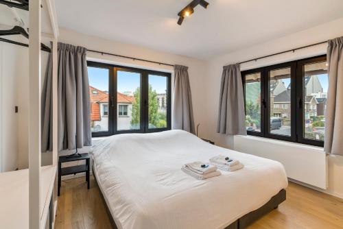 En eller flere senge i et værelse på Sublieme, ruime luxe villa 10p met terras én tuin
