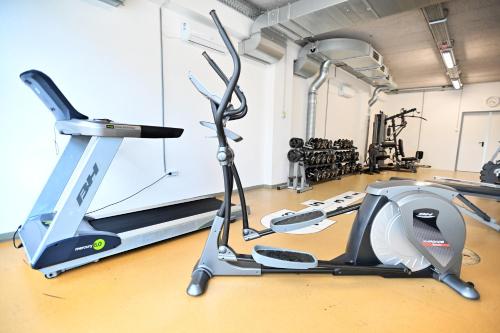 a gym with a treadmill and a elliptical machine at Hotel Eger & Park in Eger