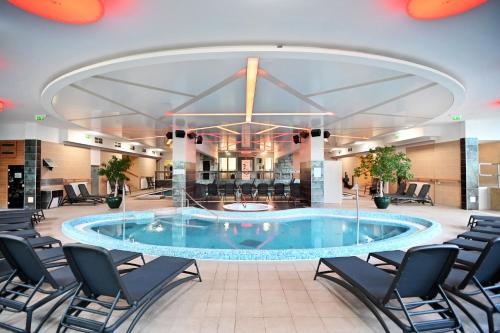 uma grande piscina no meio de um lobby do hotel em Hotel Eger & Park em Eger