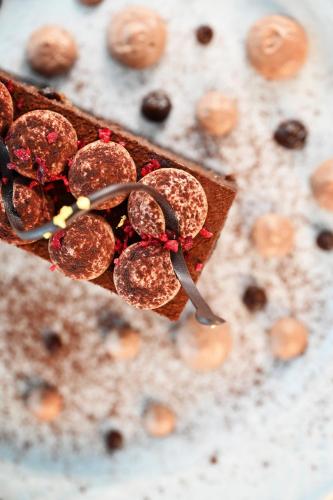a piece of cake with chocolate and cherries on it at Hotel Eger & Park in Eger