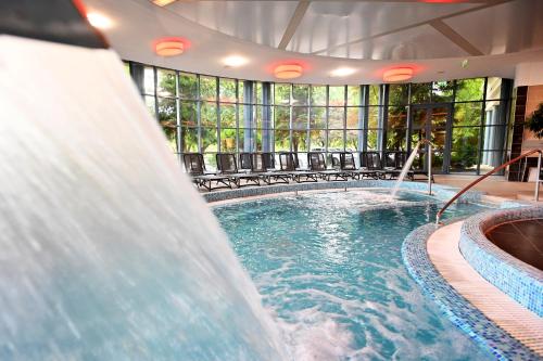 a swimming pool with a water slide in a building at Hotel Eger & Park in Eger