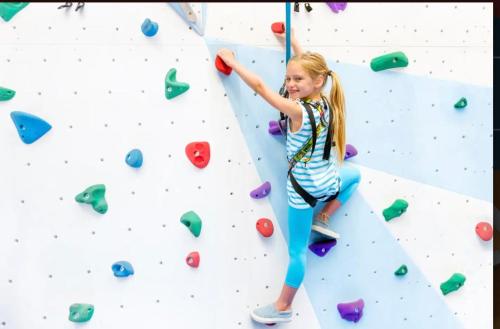 a young girl on a climbing wall at The Warren Holiday Park - Family Chalet in Abersoch