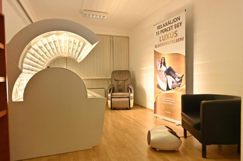 a waiting room with a chair and a sign at Hotel Eger & Park in Eger