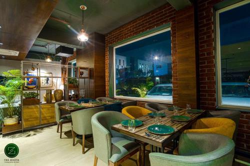 a dining room with tables and chairs and a window at The Zenith - A boutique hotel by Hot Millions in Mohali