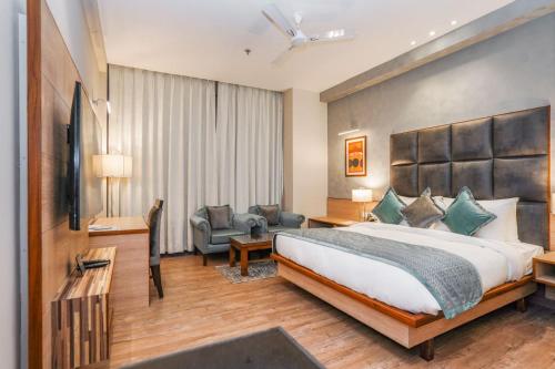 um quarto de hotel com uma cama grande e um sofá em The Zenith - A boutique hotel by Hot Millions em Mohali