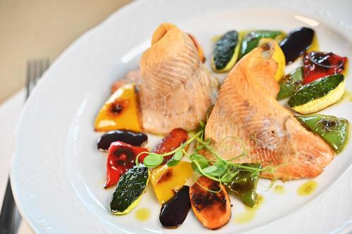 a plate of food with fish and vegetables on it at Hotel Eger & Park in Eger