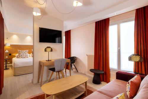 een woonkamer met een bank en een tafel bij Hotel Elysees 8 in Parijs