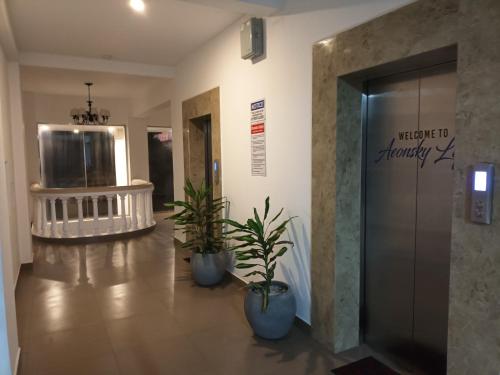 a hallway with two potted plants and a elevator at Breathtaking Luxury in Negombo in Negombo