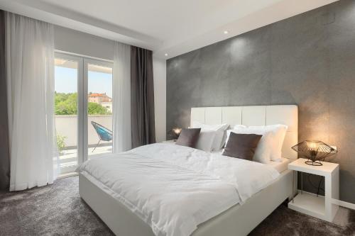een slaapkamer met een wit bed en een groot raam bij Villa Bella- White in Rovinjsko Selo