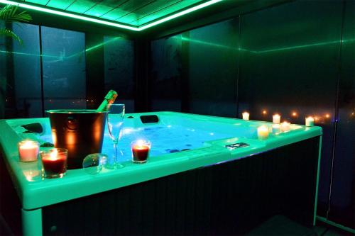 a jacuzzi tub with lit candles and candles at SuiteDreams-Jungle Suite - Liège in Liège