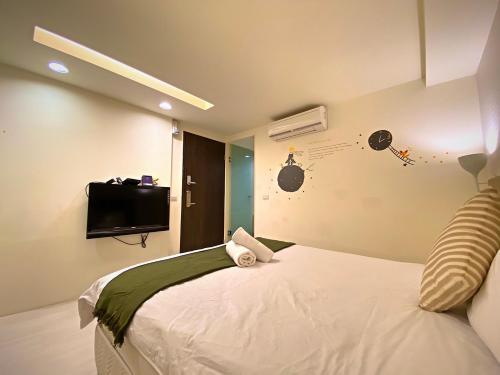 1 dormitorio con 1 cama y TV en la pared en 寵愛逢甲 en Taichung