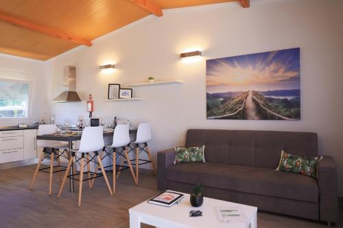 a living room with a couch and a table at Parrots`Village in Rabo de Peixe