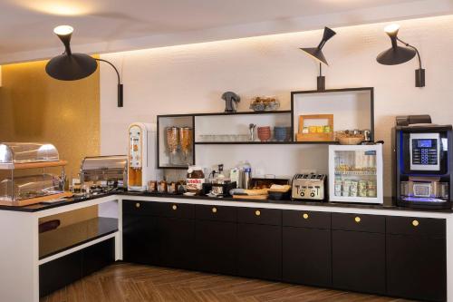 パリにあるホテル エリゼ 8のキッチン(黒いキャビネット、カウンター付)