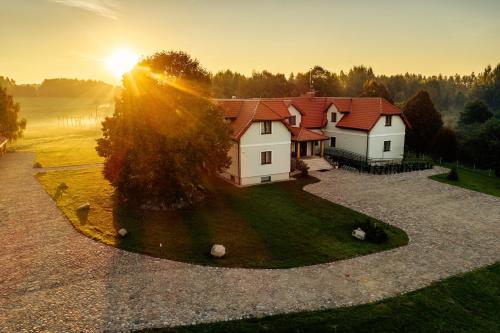 an aerial view of a house with the sun setting at Highland Warmia - Gospodarstwo agroturystyczne in Jeziorany