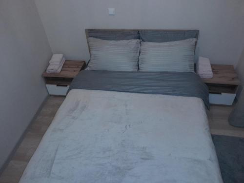 a bed in a small room with two pillows at Gray Apartament 2 Pristina in Pristina