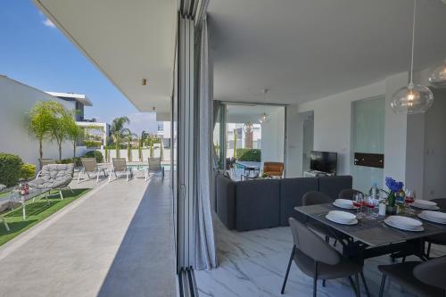 a living room with a dining table and a patio at Olivine Pearl Villas in Protaras
