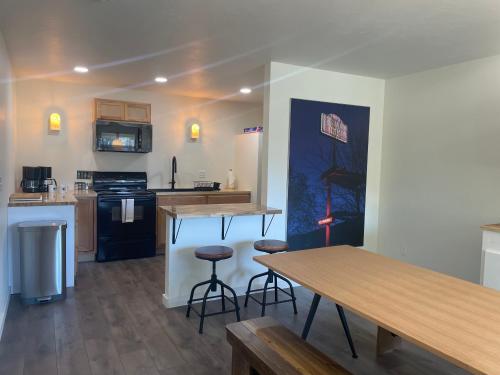 a kitchen with a table and two bar stools at Steelhead Lodge in Lucile