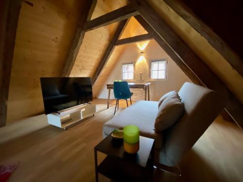 En el ático hay una sala de estar con sofá y TV. en Design-Loft Appartement, en Berchtesgaden