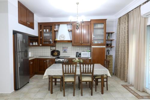 una cocina con armarios de madera, mesa y sillas en Angels' House en Tesalónica