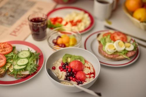 a table topped with plates of food with fruit at Töölö Towers in Helsinki