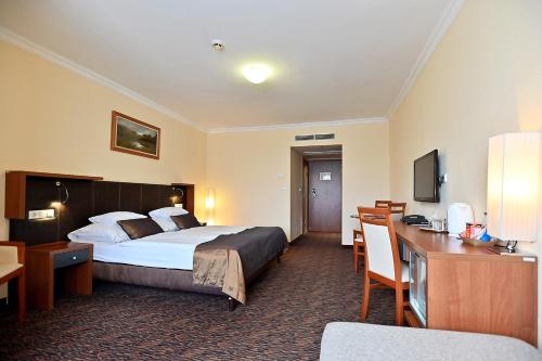 a hotel room with a bed and a desk at Hotel Eger & Park in Eger