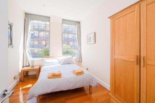 1 dormitorio con 1 cama con 2 toallas en Lovely 2 bed flat in canal side gated development, en Londres