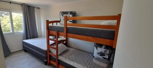 two bunk beds in a room with a window at Departamentos Lipangue in Algarrobo