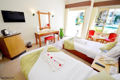 a hotel room with two beds and a desk at Falcon Hills Hotel in Sharm El Sheikh