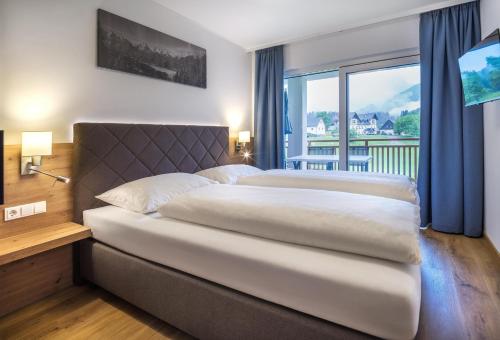1 dormitorio con 1 cama grande y ventana grande en Appartementhaus Madlen, en Hinterstoder