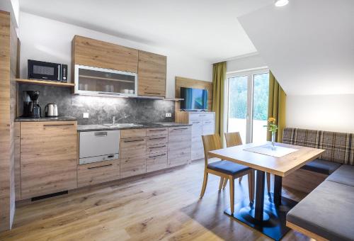 a kitchen with wooden cabinets and a wooden table at Appartementhaus Madlen in Hinterstoder