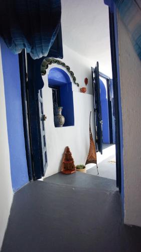 a hallway with blue and white walls and blue doors at Hotel Casa Miguel in Chefchaouene