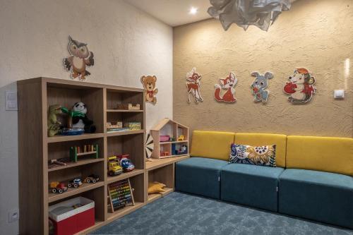 a living room with a couch and shelves with toys at Highland Warmia - Gospodarstwo agroturystyczne in Jeziorany