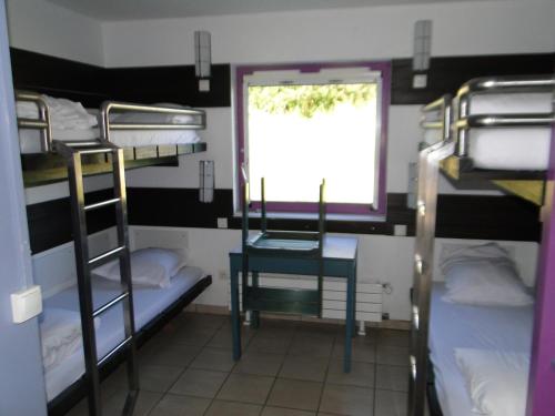Ce dortoir dispose d'une fenêtre et de lits superposés. dans l'établissement Auberge de Jeunesse HI Saint-Brieuc, à Saint-Brieuc