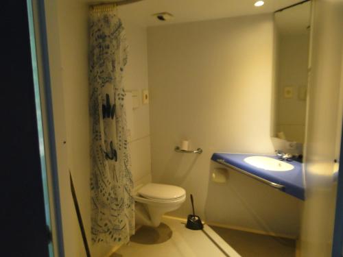 La salle de bains est pourvue de toilettes, d'un lavabo et d'un miroir. dans l'établissement Auberge de Jeunesse HI Saint-Brieuc, à Saint-Brieuc