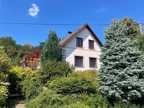 a white house surrounded by trees and bushes at Apartmán Beruška in Křelovice