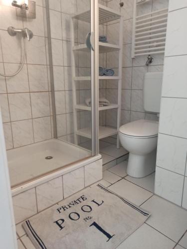 a bathroom with a shower and a toilet and a rug at Central Studio 139 in Düsseldorf