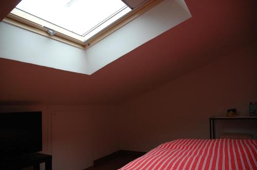 a bedroom with a skylight and a bed with red sheets at Camere Sotto le Stelle in Umbertide
