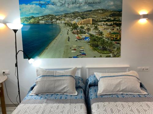 a bedroom with a picture of a beach at Apartamentos Sol y Playa Almuñecar 2 in Almuñécar