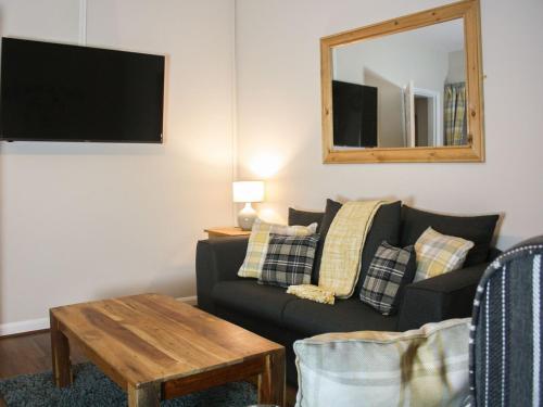 a living room with a couch and a mirror at Ring Of Bells Cottage - Ukc4274 in Orby