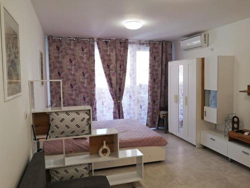 a small bedroom with a bed and a window at Comfortable Ground Floor Studio in Primorsko