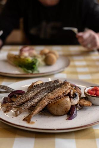 a plate of food with fish and potatoes on a table at Highland Warmia - Gospodarstwo agroturystyczne in Jeziorany