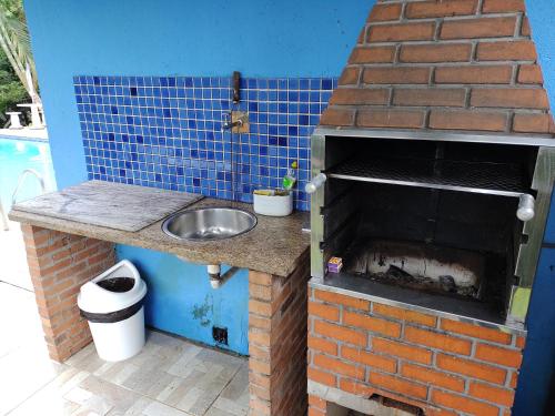 a kitchen with a sink and a brick oven at Pousada Bela Vista in Penedo