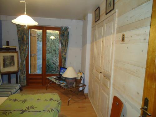 sala de estar con pared de madera y mesa con lámpara en L'Eterlou Chambres d'Hote, en Albertville