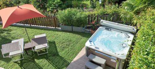 a backyard with a hot tub and an umbrella at Hilburgerhof in Schenna