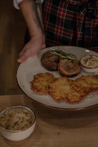 a person holding a plate of food on a table at Highland Warmia - Gospodarstwo agroturystyczne in Jeziorany