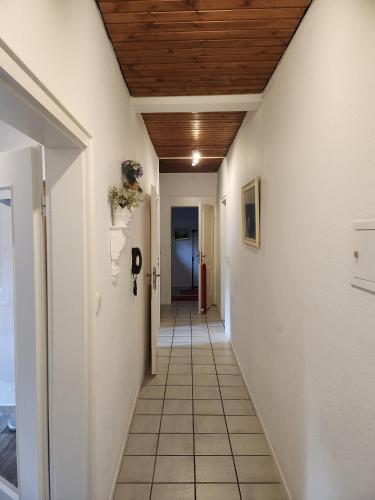 a hallway with white walls and a wooden ceiling at Gästehaus Beurener Mühle in Bad Bertrich